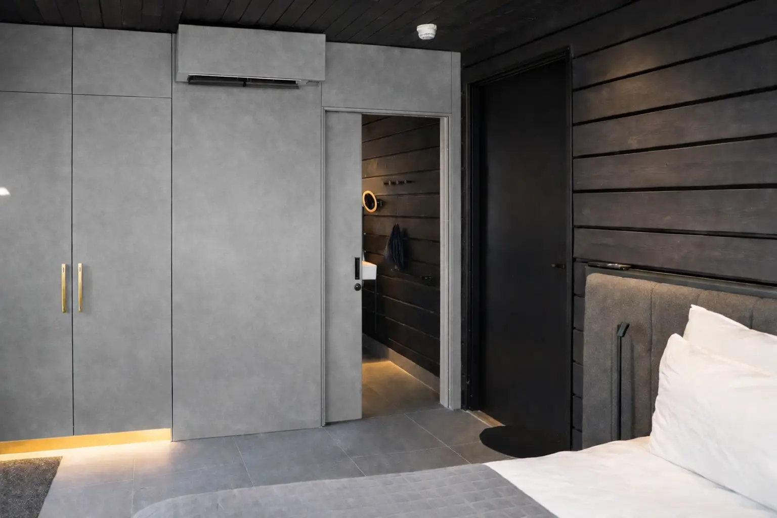 Harmaa makuuhuoneen ovi samassa s&auml;vyss&auml; sein&auml;n ja kaapin kanssa